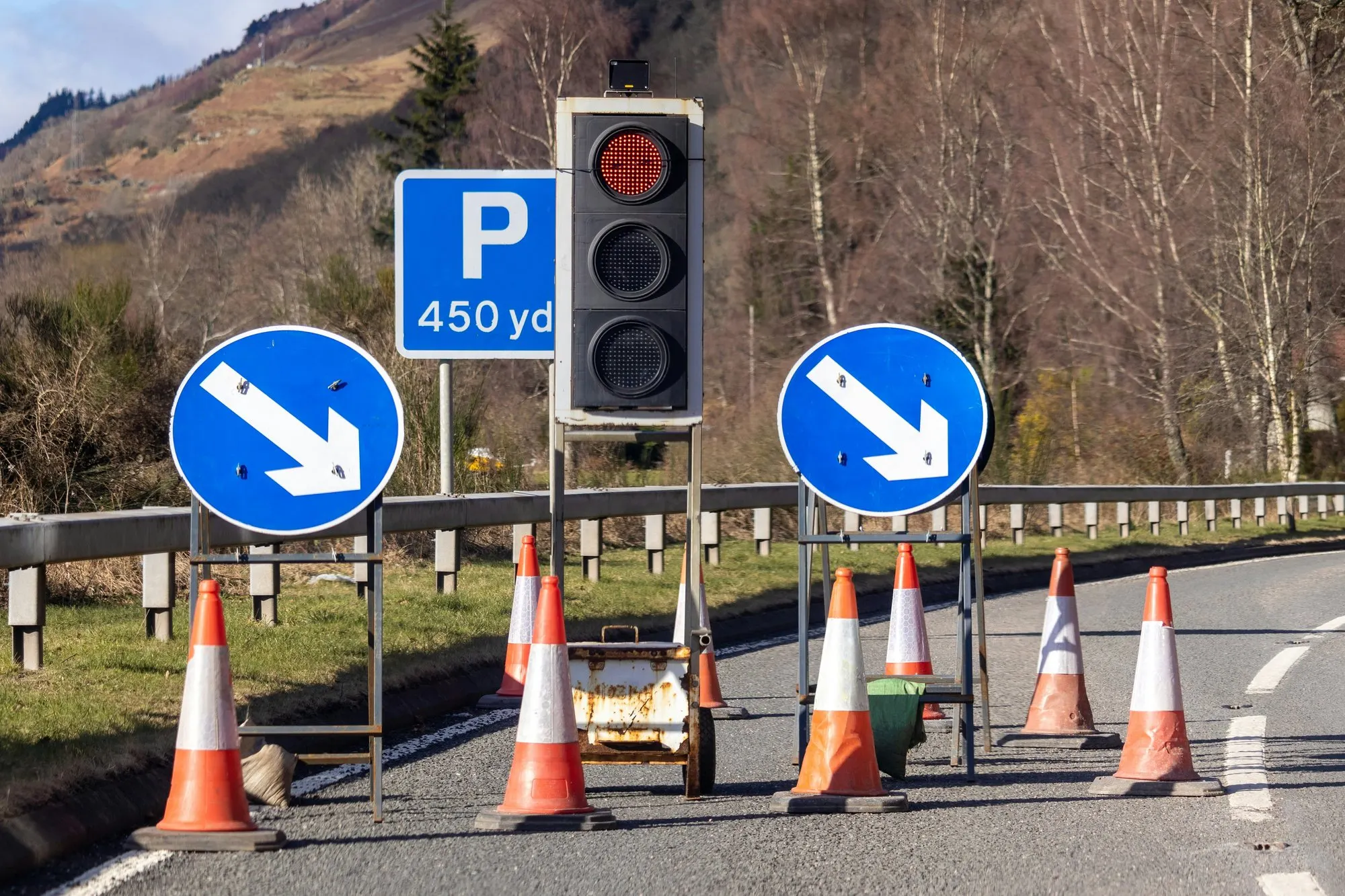Portable traffic signals, keep-right signs and cones on a rural road